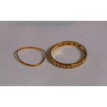 An 18 carat hallmarked gold wedding ring with relief scroll and flower decoration; a fine gold ring,