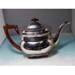 A Georgian silver teapot of rounded rectangular form, crested, on ball feet with boxwood handle,