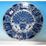 A 17th/18th century Delft shallow dish, tin glazed and decorated with flowers in the Chinese manner,