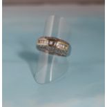 A white metal half eternity ring, the split shank set with approximately 15 baguette cut diamonds in