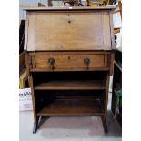 An Arts & Crafts oak bureau with fall front and shelves under
