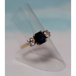 An 18 carat hallmarked gold dress ring set central rectangular cushion cut sapphire, flanked by 2