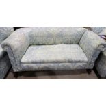 An Edwardian drop arm settee/chaise longue, upholstered in traditional blue cotton fabric