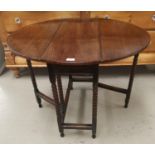 A small oak drop leaf table with oval top, on bobbin turned legs