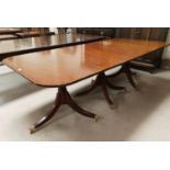 A Regency style rounded rectangular mahogany triple pillar extending dining table, the ends and