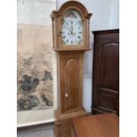 A 19th century pine 8 day longcase clock with arched top and turned pillars to the hood, arched full