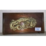 A Japanese wood and gilt metal panel depicting a dragon