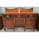 An Edwardian walnut sideboard base with carved and blind fret decoration, 3 frieze drawers and 3