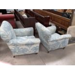 A pair of Edwardian arm chairs upholstered in traditional blue fabric