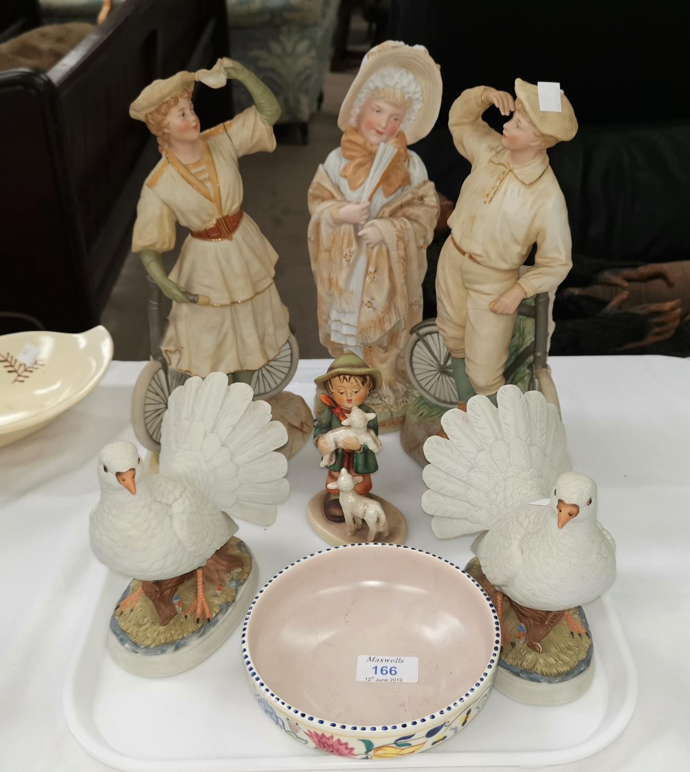 A Victorian bisque figure of a girl; 2 Victorian style figures of cyclists (a.f.); a 1950's Poole