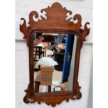 A wall mirror in mahogany Chippendale style fretwork frame