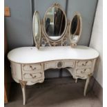 A kidny shaped dressing table in the Louis XV style, in gilt and cream