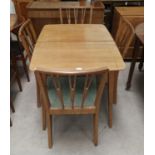 A Gordon Russell style walnut dining suite comprising extending table, 4 chairs and sideboard with