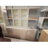 A modern limed wood effect wall unit with display cabinets and shelves over cupboards and drawers