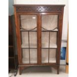 A 1930's oak display cabinet with 2 doors, beaded and blind fret decoration