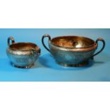A 19th century sugar bowl and cream jug with extensive chased relief decoration in the Indian