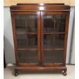 A 1930's oak bookcase enclosed by 2 glazed doors
