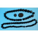 A Whitby jet necklace formed from 29 nery large facetted beads (largest bead diameter