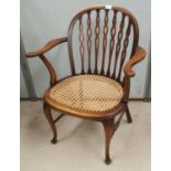 An Ercol style armchair with cane seat and pierced splats