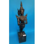 A Thai bronze figure of a goddess with hands folded in prayer and long tail on wooden plinth, height