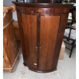 A Georgian oak crossbanded and inlaid corner cupboard enclosed by 2 doors