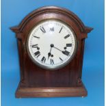 An early 20th century Georgian style mantel clock in mahogany arch top case, with white dial and