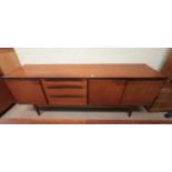 A 1960's teak lowline sideboard with 3 drawers, one double and one single cupboard, by Alfred Cox,
