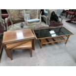 A 1960's 2 tier coffee table in teak and smoky glass; a similar nest of 3 occasional tables