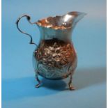 A baluster cream jug with embossed scroll decoration, London 1910, 3.25 oz