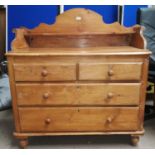 A 19th century stripped pine chest of 2 long and 2 short drawers, with low raised back and sides