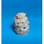 A small white hardstone carving of a coiled dragon, height 2"
