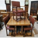 A 1930's Jacobean style carved golden oak dining suite on square carved legs, comprising draw leaf