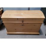 A Victorian large stripped pine blanket box with dome top