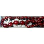 A necklace of graduated oxblood colour beads; various others