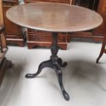 A Georgian mahogany tilt top table, the circular dish top on turned column and splay feet