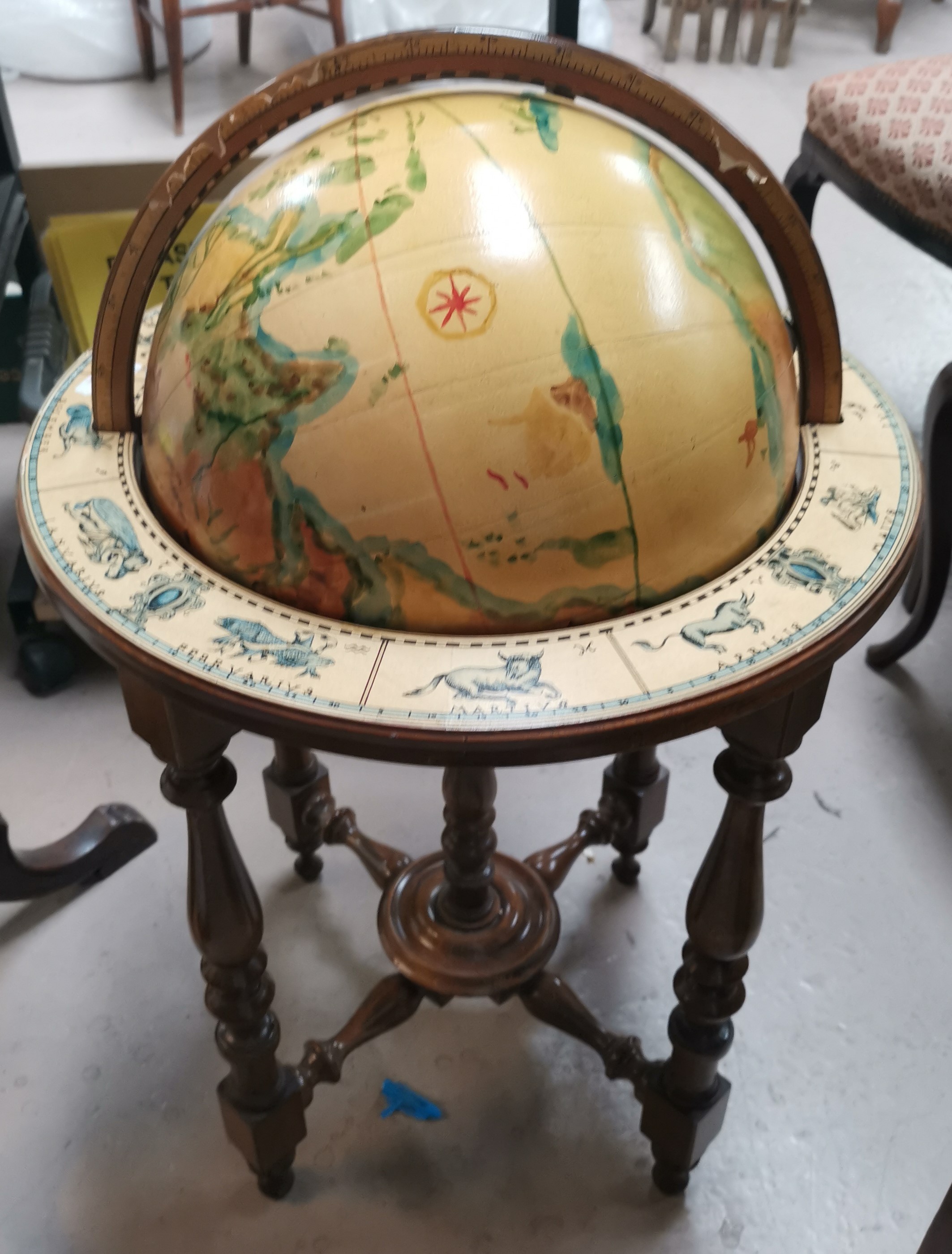 A reproduction globe on stand, with hand painted effect decoration, with zodiac signs to base