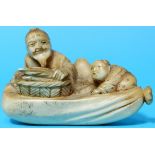 A Meiji period netsuke depicting a man with basket and child, length 6cm