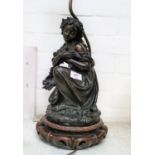 An early 20th century bronze table lamp depicting a kneeling young woman cradling a bird, on