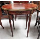 An Empire style oval occasional table with quarter veneered top and gilt metal mounts, on turned