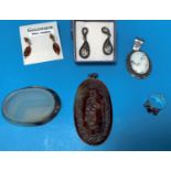 An oval brown hardstone pendant with intaglio figure of a man with staff; a white metal and