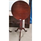 A circular early 19th century mahogany tilt top table on baluster column and 3 splay feet