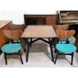 A 1950's G-Plan walnut dining suite with ebonised legs and panels, comprising drop leaf table, m4