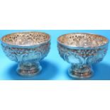 A late Victorian pair of circular pedestal sweetmeat dishes, repousse decoration, Sheffield 1898,