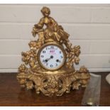 A 19th century French mantel clock in gilt metal case surmounted by a woman with dove, white