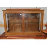 A stained walnut display cabinet with 2 doors