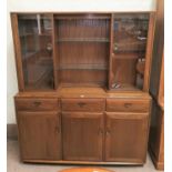 A modern Ercol full height side cabinet in medium elm, the top with 2 glazed cupboards and open