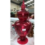 A pharmacy display jar and cover in red lustre glass