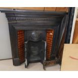 A Victorian cast iron back leaded fireplace with brown tile insets