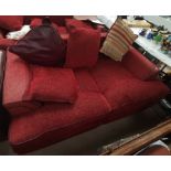 A large modern 3 seater settee in rust with leather effect piping