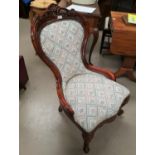 A Victorian style nursing chair with balloon back, in floral fabric